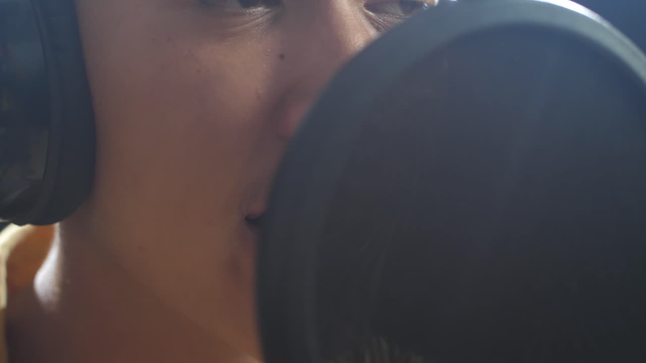 cerca de la boca del niño cantando en un micrófono condensador en el fondo negro