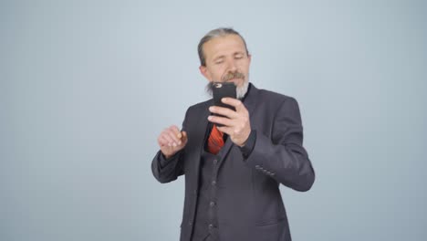 Businessman-dancing-with-phone-in-hand.