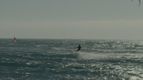 silueta de un kitesurfista masculino montando una ola en la costa de matanzas, chile