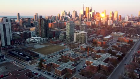 drone shot flying backwards away from regent park toronto in the morning sunrise light during a cold fall morning.