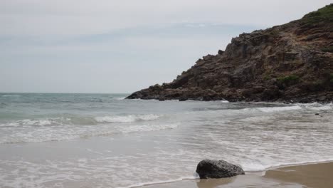 Dramatic-Scene-Of-Ocean-Waves-Gently-Lapping-On-The-Shore-With-Rocky-Cliff-Nearby-In-Bai-Da-Cuoi,-Vietnam