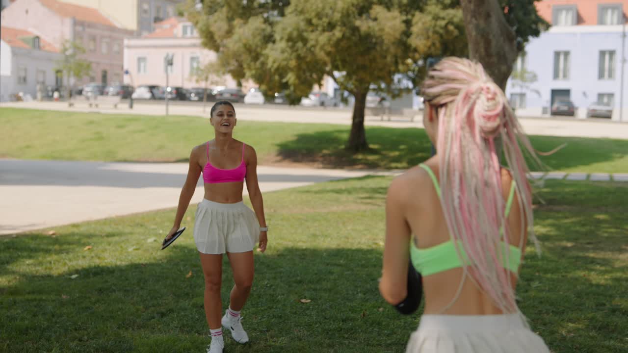 Women playing frisbee in a park