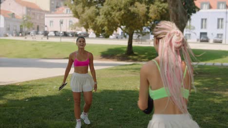 women playing frisbee in a park