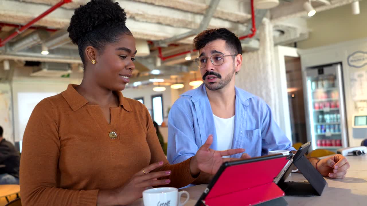 Divers collègues discutant d’idées commerciales sur une tablette dans un bureau moderne