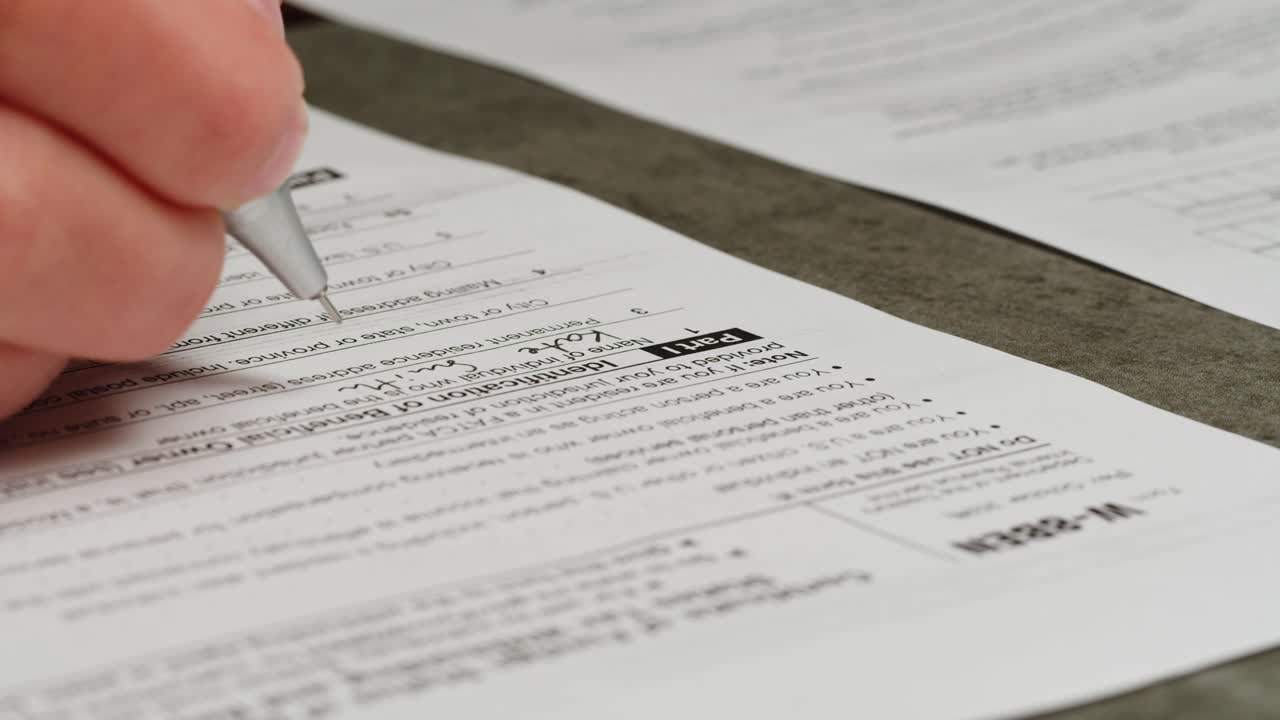 Close-up of a Hand Writing on an Official Tax Form