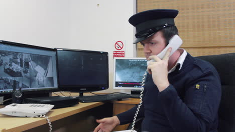 a security guard talking on the phone in a surveillance cctv room