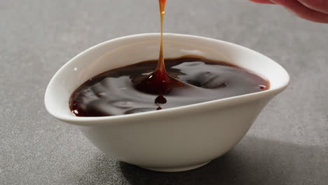 dipping a crispy fried snack in sweet and sour sauce