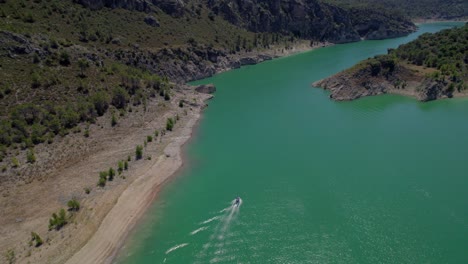 Vista-Aérea-Del-Hermoso-Paisaje-Del-Embalse-Verdoso-Bordeado-Por-Laderas-Rocosas-En-Un-Día-Soleado