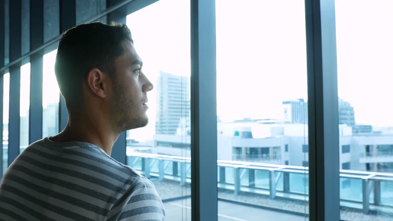 ejecutivo masculino mirando a través de la ventana 4k