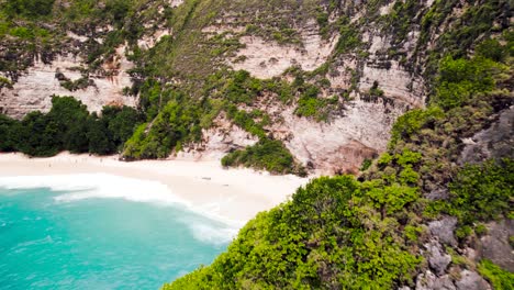 Die-Bewachsene-Küstenklippe-Offenbart-Wunderschönes-Blaues-Wasser-Und-Den-Sandstrand-Von-Kelingking,-Nusa-Penida,-Bali,-Indonesien