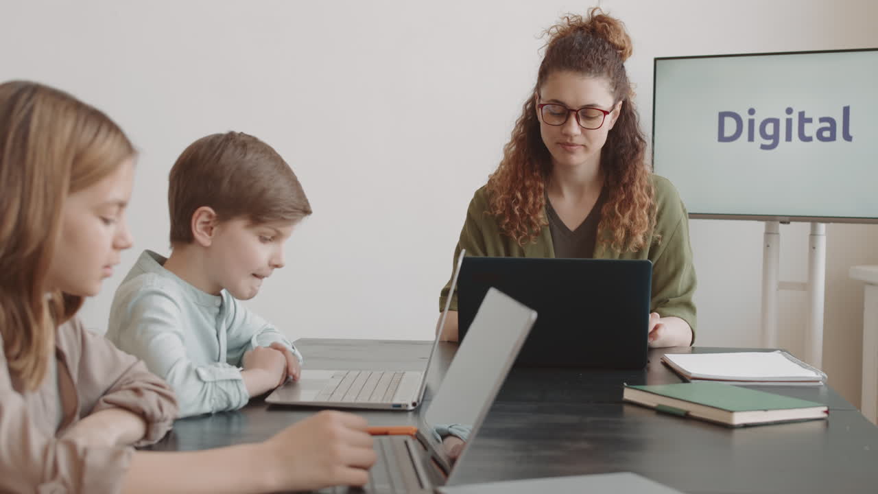 Woman Teaching Kids Using Computers