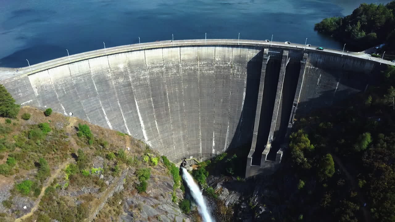 Car driving through Dam located in Montalegre, Portugal - Drone shot aerial view backwards movement