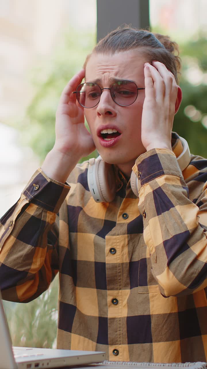 Sad unhappy man tourist using laptop receive bad news game fail loss error virus in city cafe