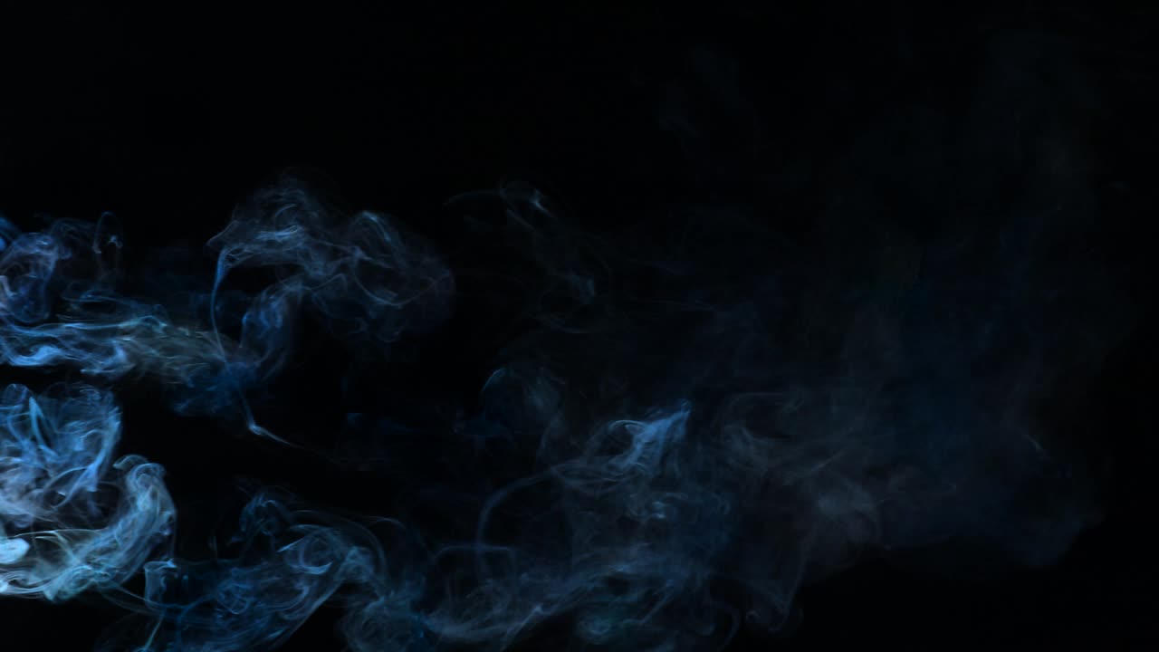 Fumo blu che filtra attraverso uno sfondo nero.