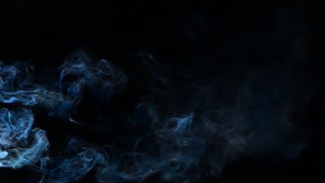 blue-colored smoke filtering through black background.