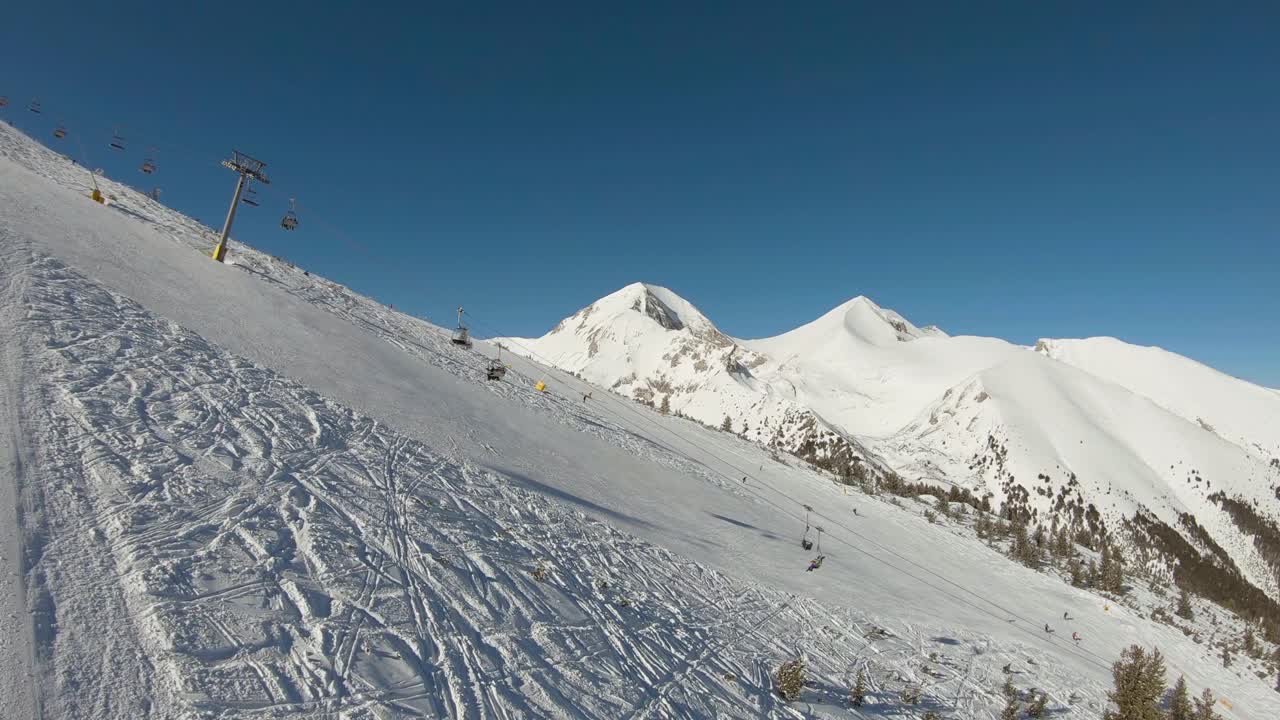 pista de esquí con remonte y montaña al fondo en un día soleado