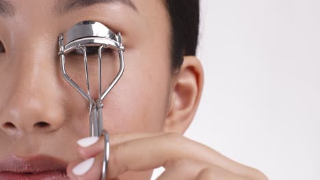 woman applying eyelash curler