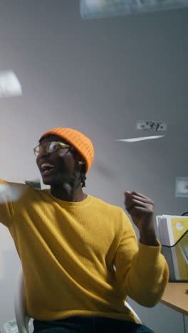 man celebrating a win with money raining down