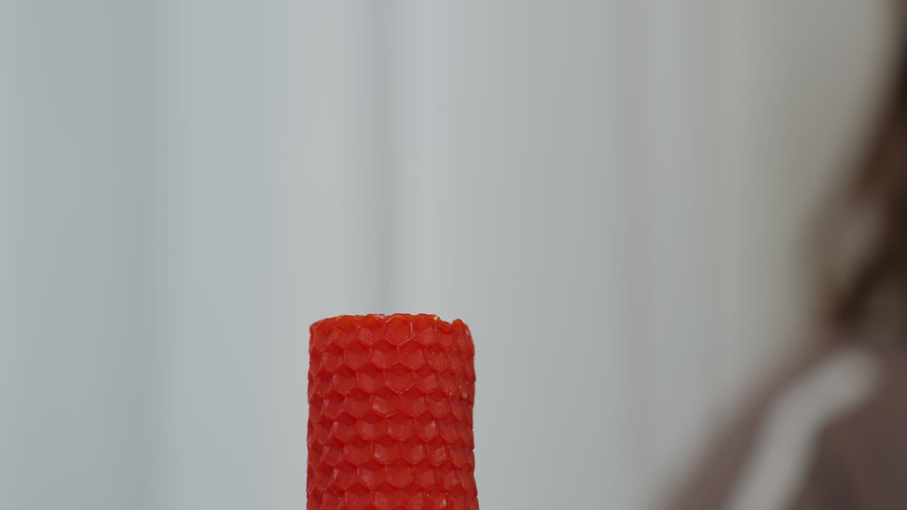 은 불이 꺼진 후 미세한 연기를 방출하는 클로즈업, 부드러운 색 커튼과 배경에 흐릿한 인물