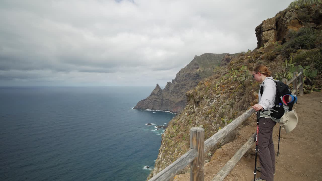 una excursionista disfruta de una vista panorámica sobre el océano en las montañas anga en tenerife, españa
