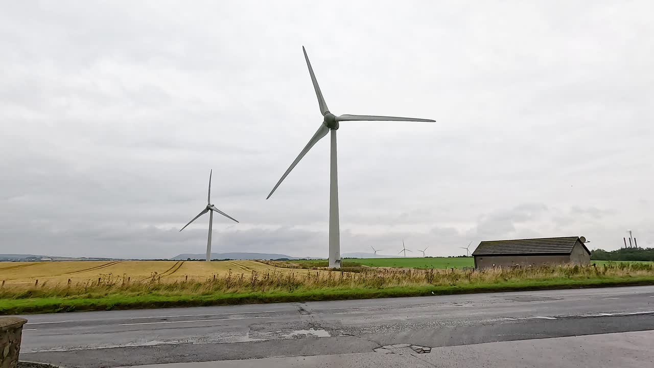 시골 건물 근처에서 회전하는 풍력 터빈