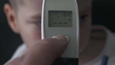 dad taking sons temperature using a digital thermometer covid 19 virus symptom - epidemic coronavirus outbreak conceptconcept