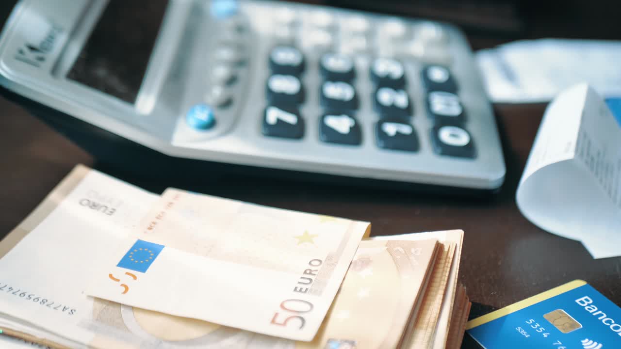 Male hand counts expenses or income on a calculator. Selective focus
