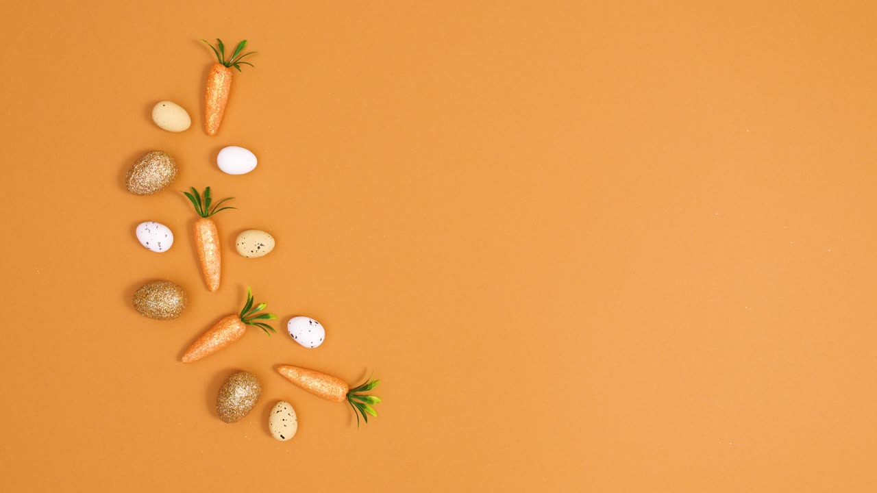 Easter minimal decoration made of eggs and carrots on left side of orange background. Stop motion