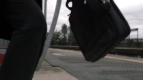 business woman walking on train platform with briefcase medium shot