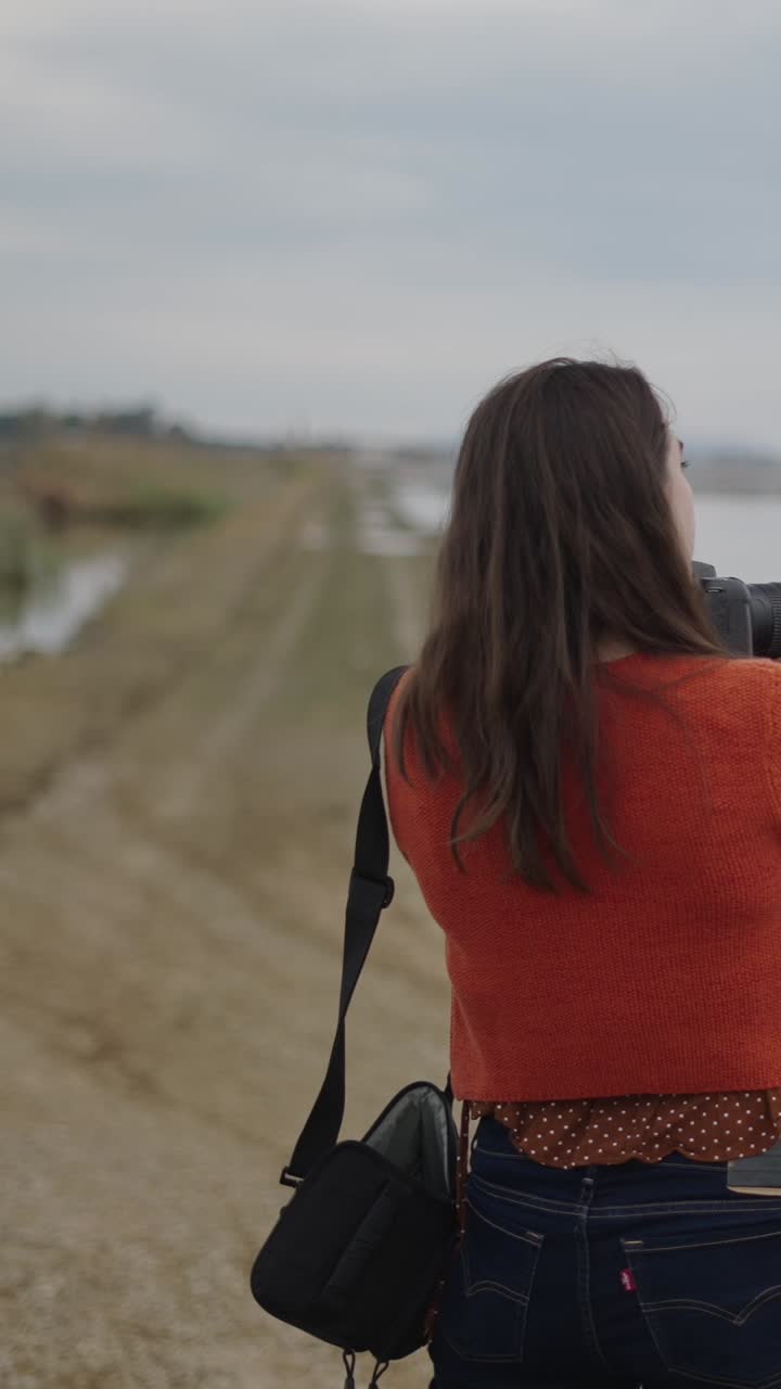 Woman taking photos of the lake