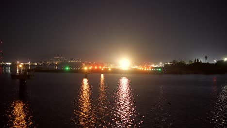 passenger plane takes off above night sea, lights and dark