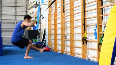 a still shot of a guy doing pistol squats inside a gymnastics gym