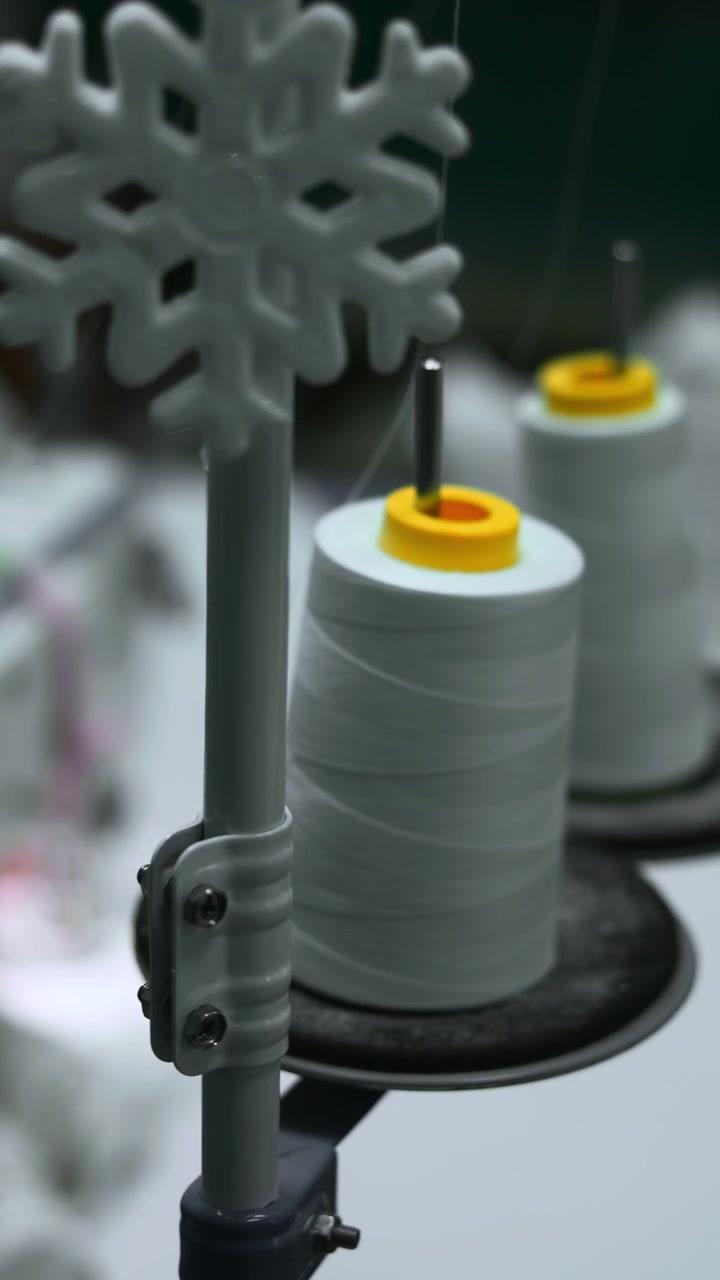 Thread Spools In Industrial Sewing Factory Foreground, White Cones And Bobbins Sharply Focused While Blurred