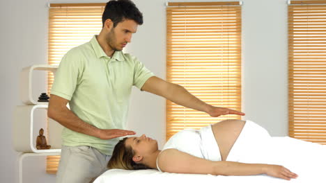 terapeuta realizando reiki en el paciente