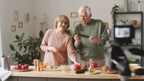 elderly couple filming online culinary class with digital camera