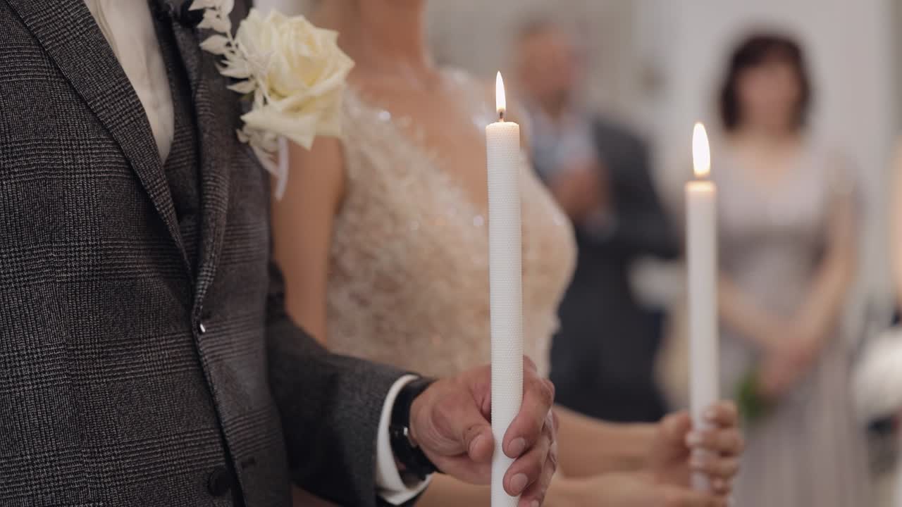 신혼부부, 신부와 신부는 교회에서 서서 기도하고, 손에 불을 들고, 결혼식