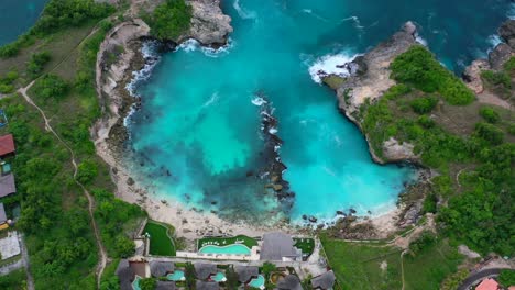 villas on a cliff at blue lagoon at nusa ceningan island, aerial top down