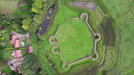 Aerial-video-footage-of-the-remains-of-Bolingbroke-Castle-a-13th-century-hexagonal-castle,-birthplace-of-the-future-King-Henry-IV,-with-adjacent-earthwork