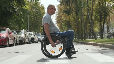 man with disabilities in wheelchair crossing street road