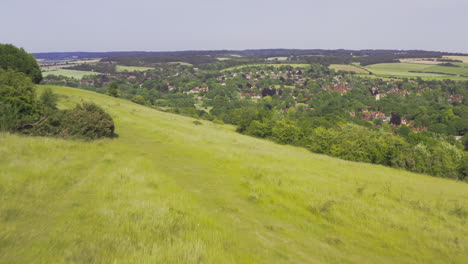 Luftdrohnenaufnahme-Einer-Frau,-Die-Mit-Einem-Hund-Auf-Einem-Hügel-In-Der-Englischen-Landschaft-Des-Vereinigten-Königreichs,-Berkshire,-Sitzt