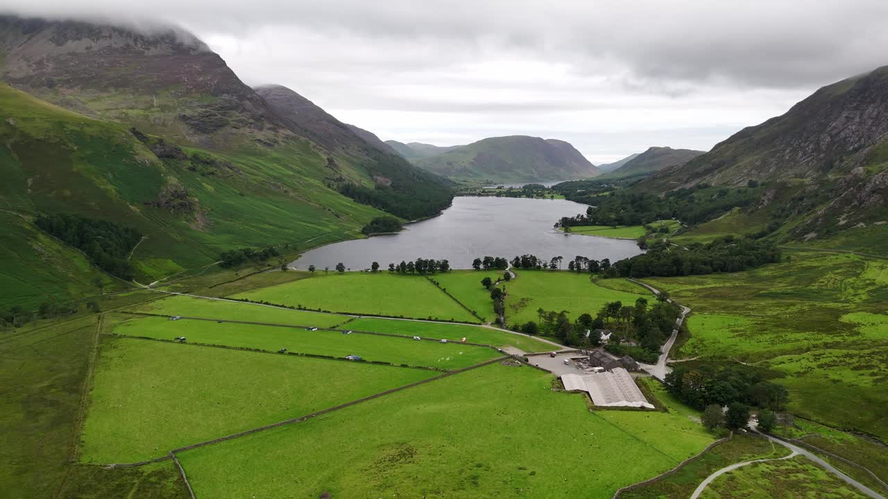 Aerial wide drone shot of Buttermere in the Lake District on a moody, overcast day with mountains, forest and lake