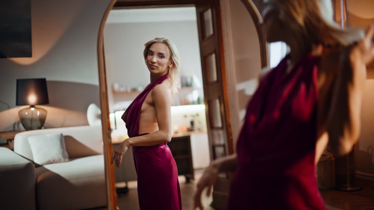 Gorgeous blonde looking mirror reflection trying party dress closeup. Sexy woman