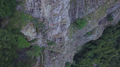 ascending wide aerial view from drone of people climbing mountain at high altitude