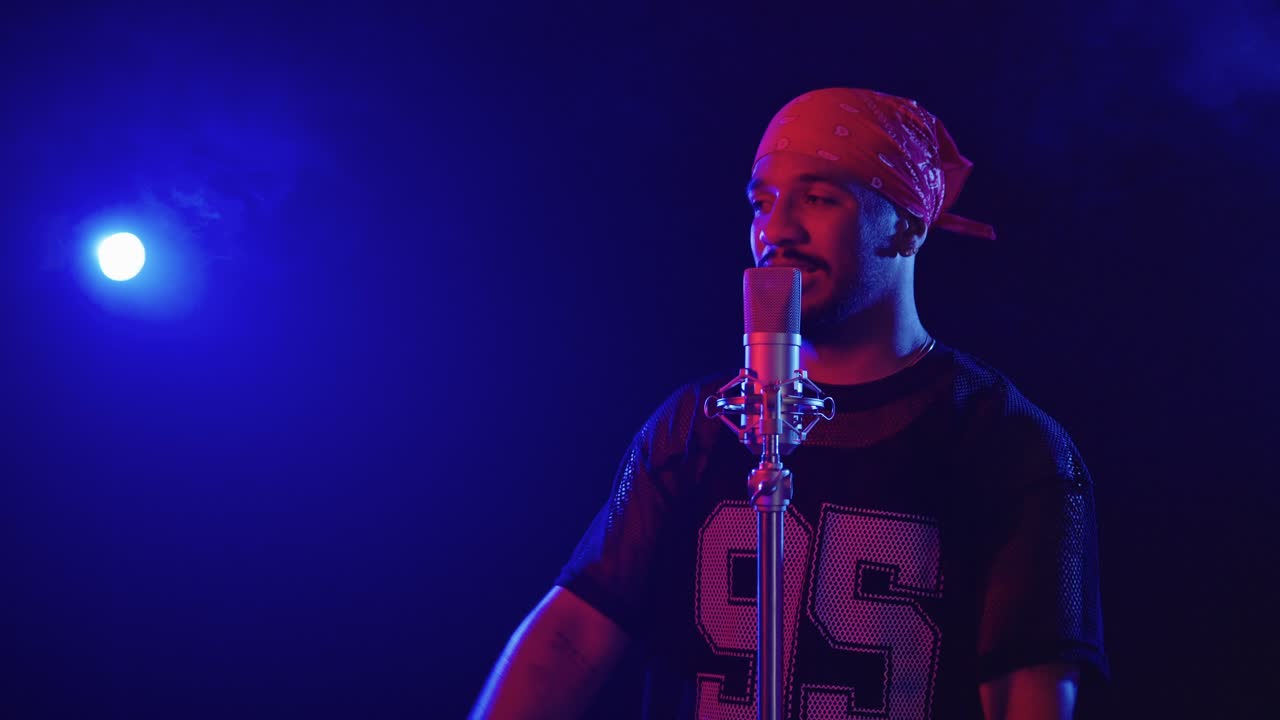 Uomo che canta al microfono in uno studio musicale