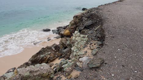 sea wall and ocean road damage and corrosion, crumbling away into ocean, impacts of climate change, rising tides and lack of maintenance