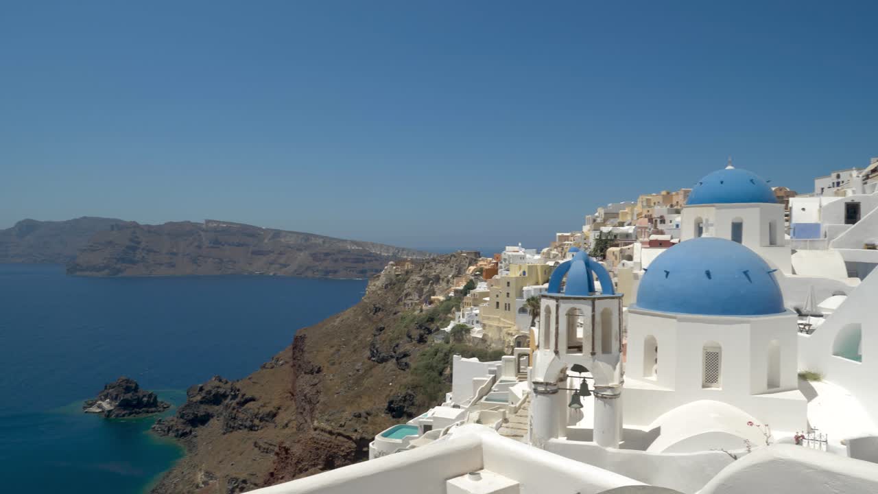 Pan right, Caldera view to beautiful blue rooftop church, santorini, greece