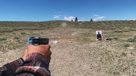 Man-shooting-a-glock-9mm-handgun-at-firing-range-target,-slow-motion,-desert