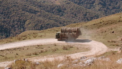 truck carrying hay bales on a mountain road