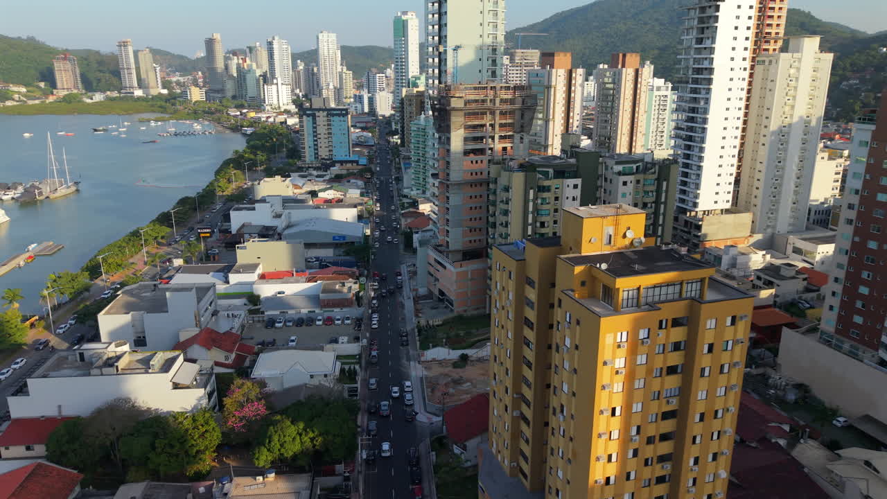 Movimento de drone em descida próxima entre edifícios residenciais modernos de grande altura em Itajaí, Santa Catarina, Brasil