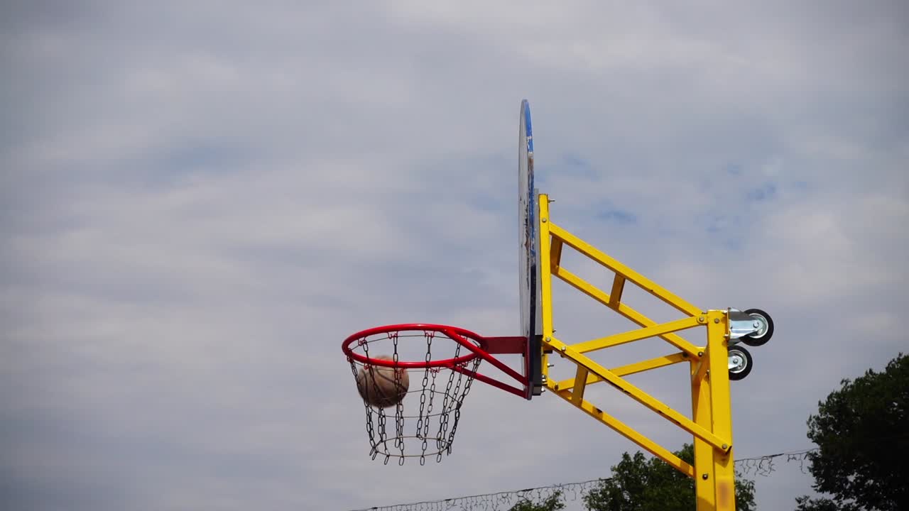Pallacanestro da strada. La palla vola verso il canestro. Al rallentatore